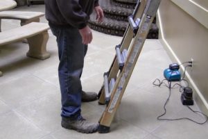 feet at the base of an extension ladder