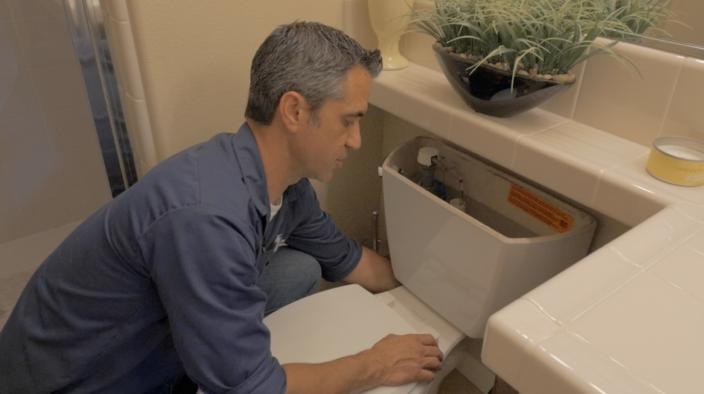 plumbing contractor working on toilet