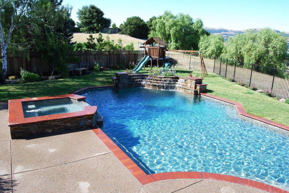 swimming pool with hot tub and waterfall