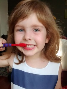 little girl brushing her teeth